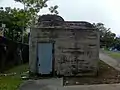 The entrance-door of the pillbox with the top of the observation cupola also seen.