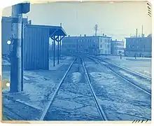 A wooden shelter next to a streetcar line in an urban area