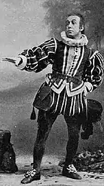 Man in Tudor costume gesticulating theatrically