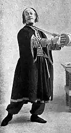 Man in Middle-Eastern costume, playing a small drum