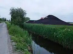 Pile of extracted peat with excavators