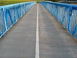 First-person perspective view, looking along the deck of the Bay Farm Island Bicycle Bridge