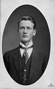 Black and white, head and shoulders portrait of a man in a suit.