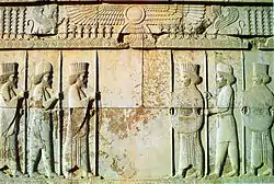 Stone relief depicting two groups of three men facing each other