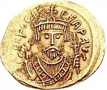 A gold coin with the bust of Phocas. His eyes form the central focus of the image