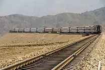 Train running between mountains in Toksun County, Turpan