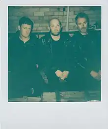 Three band members sitting outside of rehearsal studio in Melbourne