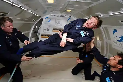 Hawking, without his wheelchair, floating weightless in the air inside a plane