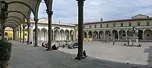 Square surrounded by colonnades with an equestrian statue in the center