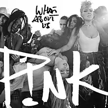 A black-and-white image of a group of people sitting close and embracing each other. The words WHAT ABOUT US are written in black capital letters at the top, while P!NK is written in white capital letters in the lower part of the image.