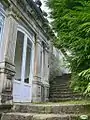 Side of the façade with the staircase and the door