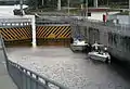 Boaters anchored lock wall as the canal-side gates close.