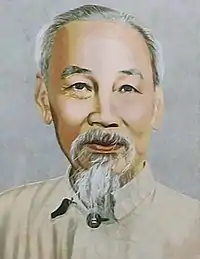 Headshot of an older man with grey-white facial hair and a goatee wearing a cream shirt