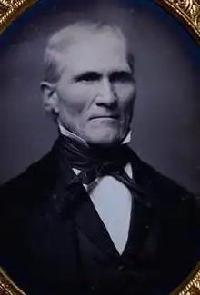 A black and white photograph of Sargent of him sitting wearing a suit and tie