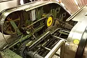 Escalator truss connects to the landing platform (lower left). Also visible: exposed drive gears (center) for steps and handrail drive (left).