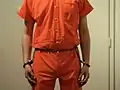 Inmate in belly chain with the arms cuffed parallel at the side