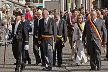 Patrick Moenaert, Mayor of Bruges (left), and Paul Breyne, Governor of Western Flanders (right), both in morning dress along with formal trousers at the Sanguis procession in Bruges, Belgium.