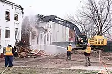 An image of Maryland governor Larry Hogan operating an excavator to demolish a vacant building in Baltimore