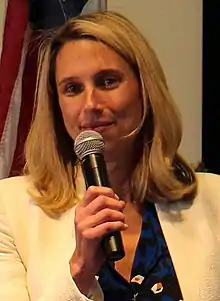 Simmons sitting on a chair for a mayoral debate