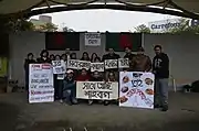 Bangladeshis of all ages holding signs in a Park in Taiwan