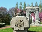 Pillar at the entrance to the war memorial showing French Army helmet on flag positioned above the Croix-de-Guerre.