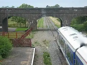 Brick bridge over the railway line immediately next to a railway platform