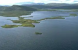 View of the lake with an island in the foreground and mountain range in the background