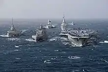 The French Navy as planned for the late 2030s: a Bâtiment ravitailleur de forces (fleet tanker) conducts simultaneous underway replenishment with the Future French aircraft carrier and with a Frégate de défense et d'intervention (Defence and Intervention Frigate).