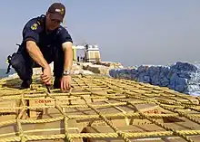 Image 24A sailor from HMAS Adelaide inspecting a ship in the Persian Gulf during 2004 (from History of the Royal Australian Navy)