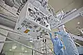 A view of the RRM on the underside of the LMC in the SSPF with technicians for scale