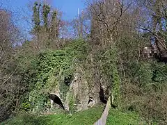 An old, brick furnace with overgrown vegetation.