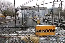 A sign saying "Rainbow Trout" next to pools of water for fish.