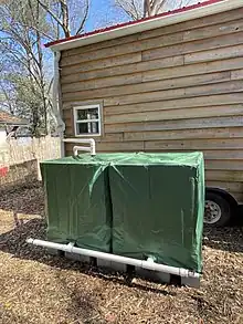 Rainwater is collected from a rooftop of a tiny house and then diverted into two 275 gallon IBC totes.  This is an affordable way to capture water for the gardens, livestock, and other land lab uses.