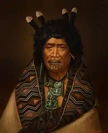 A portrait of Rangi Topeora, wearing numerous pounamu items.