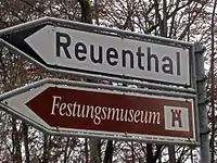 Direction signs for a minor route to a destination (white) and tourist attraction (brown) in Switzerland