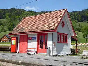 White single-story structure with red trim