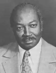 Black and white picture of a man in a suit and tie with his head turned slightly to one side