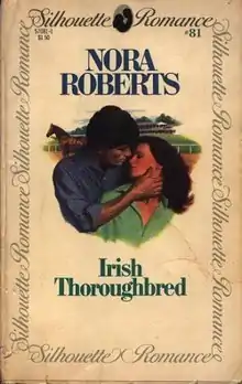 The center of the cover shows the head and torso of a woman with long hair, leaning against the head and torso of a man. The man's right hand cups her neck, and the couple are looking at each other.  In the background are a horse and a large building. Above the image are the words "Nora Roberts" and "Irish Thoroughbred". The outer edges of the cover have a solid border, with the words "Silhouette Romance" repeated.  In the top right corner is the number 81.