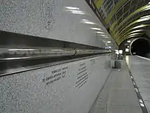 A glass tube containing geological samples including some from Boring Lava Field is seen running along the wall of the Washington Park station platform.