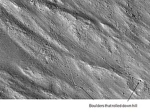 Enlargement of cliff in Kasei Valles system in previous image showing boulders and their tracks, as seen by HiRISE.  Click on image to see a boulder only 2.2 yards across (smaller than a bedroom).