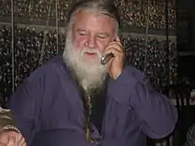 Photo of a seated man with a long white beard