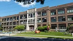 Roosevelt, a wide three-story building of brick and beige stone