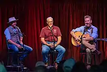 Feek on stage with Gabe Mccauley and Joel Salatin at the Music Ranch Montana on July 10, 2021