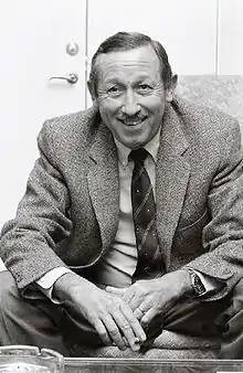 Roy E. Disney sitting in a suit and grinning