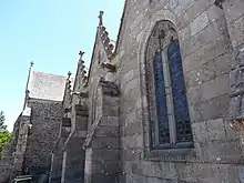 Photo of a granite church wall, with three gargoyles