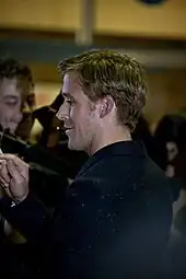 Ryan Gosling as he acknowledges the press at a red carpet premiere.