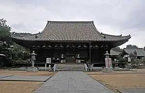 Wooden building with a hip-and-gable roof.