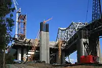 Western end (W2): Western end counterweight, behind (YBITS) approach structure columns, SAS Tower (T1) scaffold/gantry beyond. On the right is the 1936 bridge.