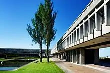 The exterior of a grey building, with a grassy garden area outside