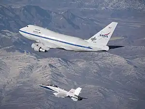 An F/A-18 mission support aircraft shadows SOFIA during a functional check flight.